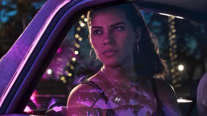 A woman in a car window, pink neon reflected on the glass.