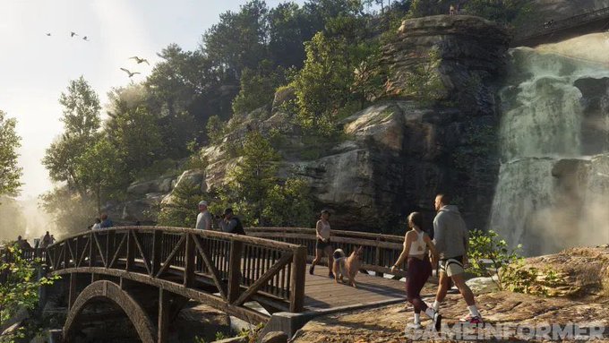 People crossing a wooden bridge in front of a waterfall.